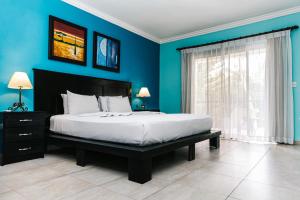 1 dormitorio con 1 cama grande y paredes azules en Hotel Brisa, en Punta Cana