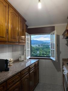 eine Küche mit einem großen Fenster mit Aussicht in der Unterkunft Casa da Quinta da Mata in Cabeceiras de Basto