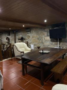 ein Wohnzimmer mit einem Holztisch und einem TV in der Unterkunft Casa da Quinta da Mata in Cabeceiras de Basto