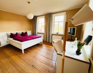 Un dormitorio con una cama con almohadas rojas. en Altes Pfarrhaus Neustädt en Neustädt