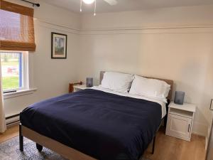 una camera da letto con letto con lenzuola blu e cuscini bianchi di OH Victoria Hotel - Sand Dune Suite 4B 3BTH a Hampton 