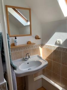une salle de bain avec un lavabo et un miroir dans l'établissement Appartement Duplex 2 pièces - Corps de ferme, à Montépilloy