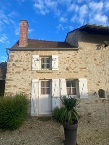 une vieille maison en pierre avec des portes et des fenêtres blanches dans l'établissement Appartement Duplex 2 pièces - Corps de ferme, à Montépilloy