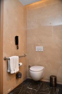 łazienka z toaletą i telefonem na ścianie w obiekcie Fairmont Quasar Istanbul Hotel w Stambule