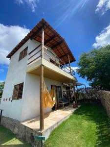 uma casa branca com uma varanda em cima em Chalé dos ventos Macapá em Ponta do Anel