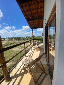 porche con silla y vistas a un viñedo en Chalé dos ventos Macapá en Ponta do Anel