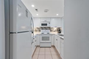 默特爾海灘的住宿－Ocean Creek Resort B4 - Oceanfront - Windy Hill，厨房配有白色橱柜和冰箱。