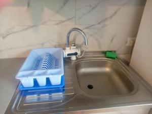 a kitchen sink with a blue tray and a faucet at Casa rustica Cerdacul Batranesc in Urlueşti +59 photos
