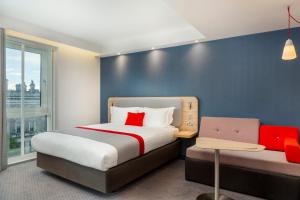 1 dormitorio con 2 camas y pared azul en Holiday Inn Express Dublin City Centre, an IHG Hotel, en Dublín