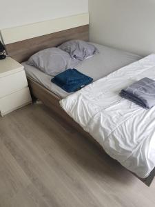 an unmade bed in a bedroom with a wooden floor at Chambre Neuve dans un logement partagé in Allonnes