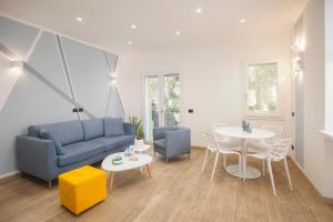 - un salon avec un canapé bleu et une table dans l'établissement 0.8 Guest House, à Porto Ercole