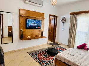 Ocean Life Dahab في دهب: غرفة معيشة مع سرير وتلفزيون على الحائط
