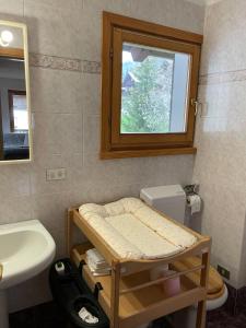 a bathroom with a sink and a toilet and a window at L'Atelier du Temps - Moline Paradiso in Cogne