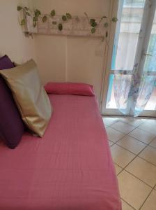 een groot roze bed in een kamer met een raam bij Bilocale centro storico in Pesaro