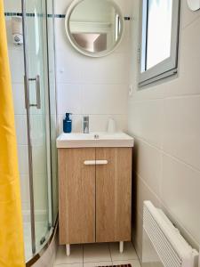 uma casa de banho com um lavatório e um chuveiro em Appartement lumineux et terrasse vue mer et jardin em Vaux-sur-Mer