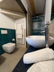 a bathroom with a white sink and a toilet at Caivano Rooms New Opening in Torri del Benaco +12 photos