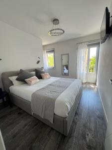 a bedroom with a large bed and a window at Caivano Rooms New Opening in Torri del Benaco +12 photos