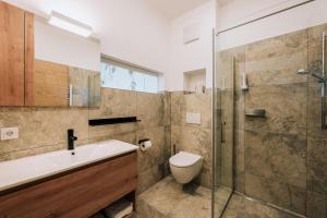 La salle de bains est pourvue de toilettes, d'un lavabo et d'une douche. dans l'établissement Weingut Radl, à Klöch