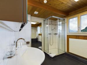 y baño con ducha y lavamanos. en Bergblick Lodge - 3 Sterne Garni - Neueröffnung, en Aeschi
