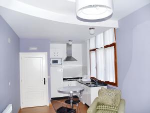 cocina blanca con mesa y silla en One bedroom apartement with shared pool enclosed garden and wifi at San Antolin de Ibias, en San Antolín
