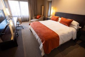 a hotel room with a large bed with orange pillows at Libertador Hotel in Buenos Aires