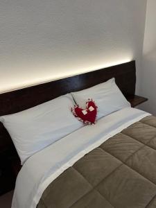 un letto con un cuscino rosso a forma di cuore di Casa Sofia a Calascio
