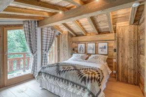 een slaapkamer met een bed en een groot raam bij Chalet River in Megève