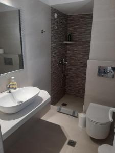 a bathroom with a sink and a toilet and a shower at Asteri Hotel in Ornos