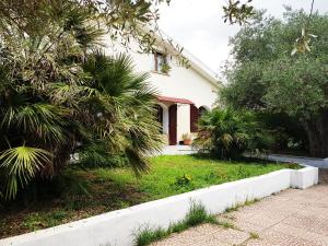 a white house with palm trees and a driveway at Villa del Mar Country Loft in Sassari