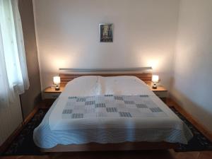 ein Schlafzimmer mit einem Bett und zwei Lampen an zwei Tischen in der Unterkunft Matea in Gospić