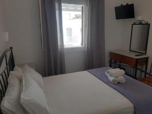sypialnia z łóżkiem, oknem i telewizorem w obiekcie Asteri Hotel w mieście Ornos