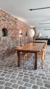 a long wooden table in a room with a brick wall at Hotel Lohauser Hof in Düsseldorf