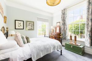 a white bedroom with a bed and a window at Spa Villas Boutique Apartments in Gloucester
