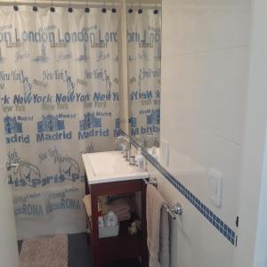 baño con lavabo y cortina de ducha en CONFORT BELGRANO en Buenos Aires