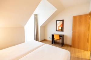 a bedroom with a bed and a desk with a mirror at Apartamentos Maritimo Ris con garaje in Noja +118 photos