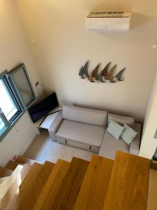 a living room with a couch and surfboards on the wall at lefkas lovely home in Lefkada Town