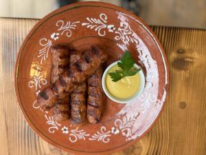 un plato de comida con salchicha y mostaza en una mesa en Barlogul din Vidraru en Curtea de Argeş