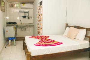 a bedroom with a bed with a red and white blanket on it at Hotel Casa Telma in Santa Marta