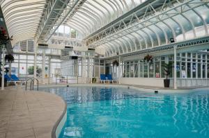 une grande piscine avec un plafond en verre dans l'établissement Basingstoke Country Hotel & Spa, à Hook