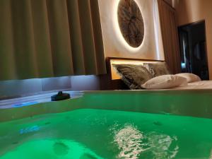 - un bain à remous dans une chambre d'hôtel avec de l'eau verte dans l'établissement Terre di Sveva, à Castel del Monte