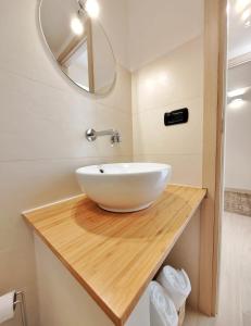 a bathroom with a white bowl sink on a wooden counter at Dimora Barbacana in Monopoli