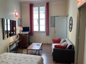 een kamer met een bed, een bank en een raam bij AU CENTRE DU FESTIVAL in Avignon