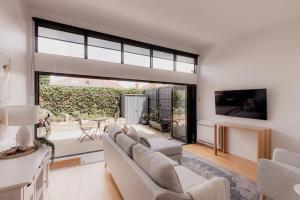 霍巴特Stay steps from Salamanca in historical cottage的客厅里有一张沙发和一台电视