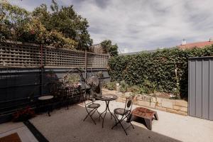 霍巴特Stay steps from Salamanca in historical cottage的带桌椅和栅栏的露台