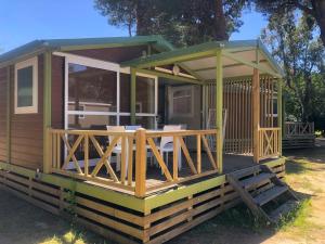 a cabin with a deck with chairs on it at Camping Dolce Vita in Calvi