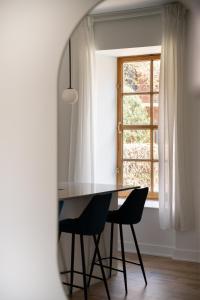 a dining room table with two chairs and a window at Maison Rasco by Luxury In Transit in Montréal