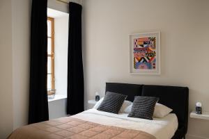 a bedroom with a bed with black curtains and a window at Maison Rasco by Luxury In Transit in Montréal