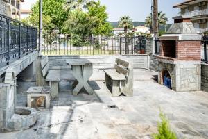 a park with two benches and a fireplace at ANGO First Floor Apartment in Stavros