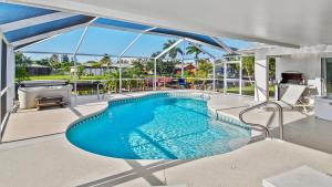 an indoor swimming pool with blue water in a house at Belloccia With Pool And Spa Best Boating Location in Cape Coral