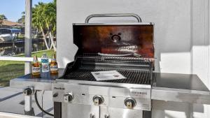 a barbecue grill with two bottles of beer on it at Belloccia With Pool And Spa Best Boating Location in Cape Coral